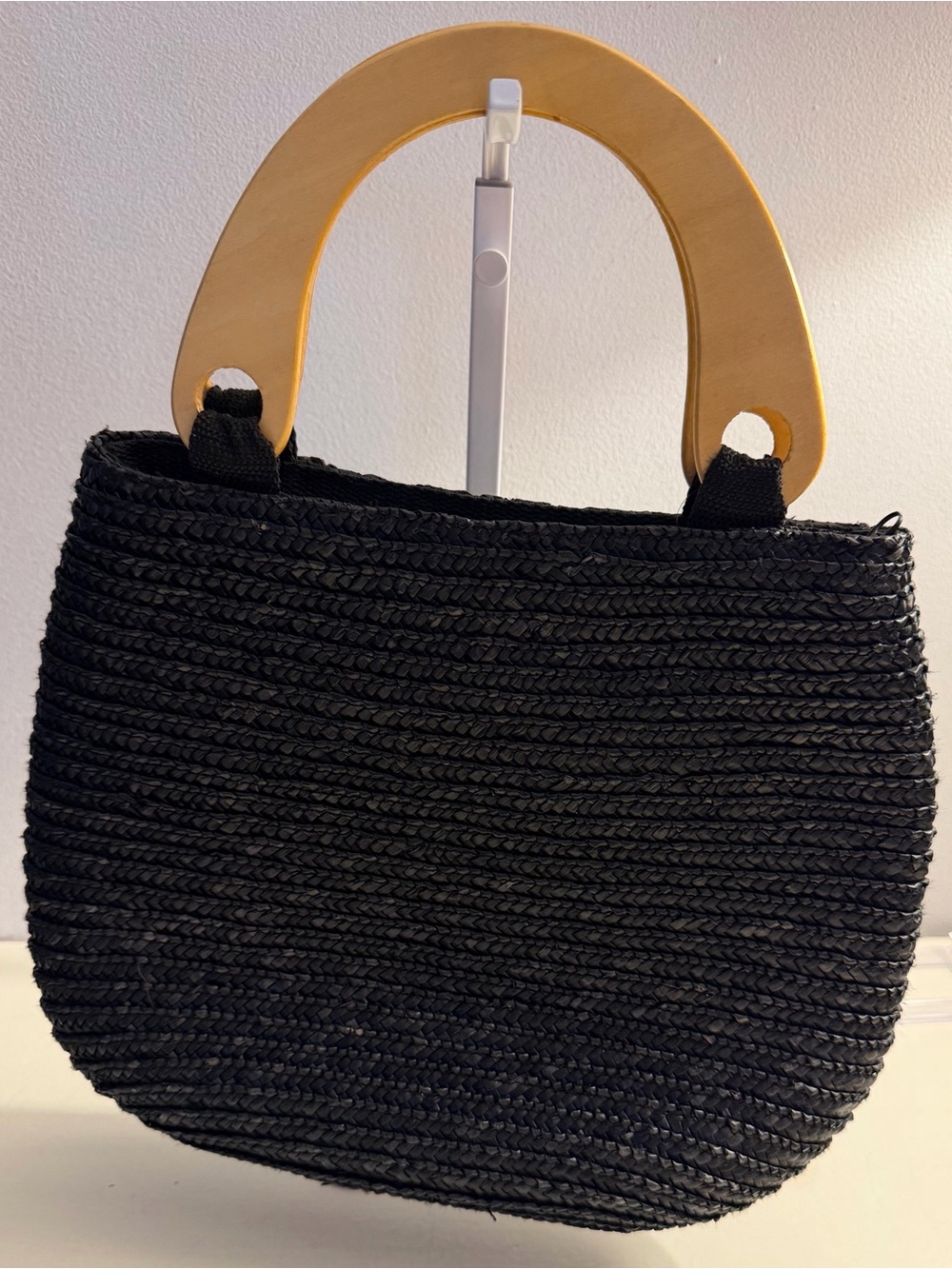 Straw-like unbranded bag with wooden handles.